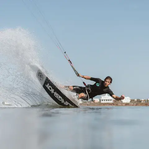 Rider de kitesurf en pleine glisse sur eau plate