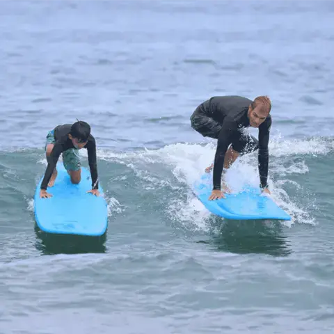 Deux surfeurs debout sur des planches de mousse
