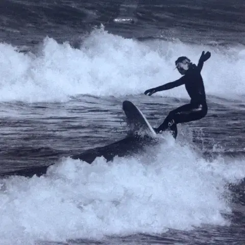 Surfeur sur une vague, en noir et blanc
