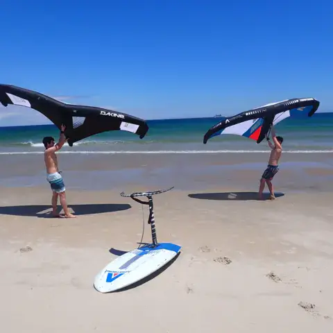 Deux élèves avec leurs ailes sur la plage