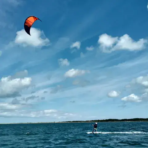 Rider de kitesurf au large, kite dans le ciel