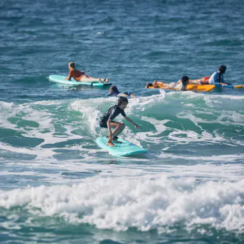 Cours de surf dans les vagues, élèves et moniteurs