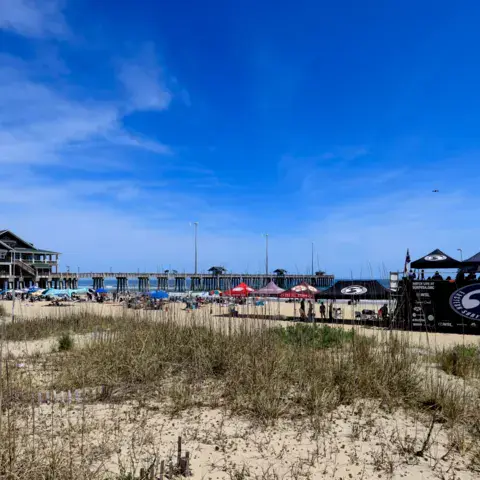 Site d'une compétition de surf avec tentes et jetée