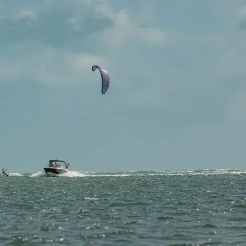 Bateau au large avec un kite dans le ciel