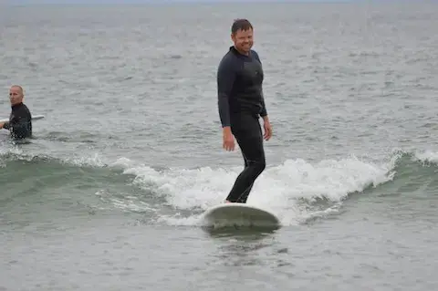 Adulte debout sur sa planche pendant un cours