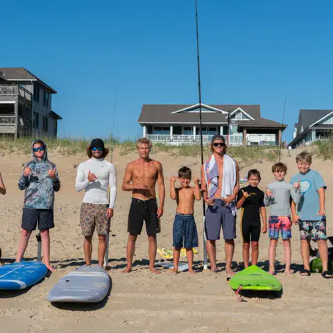 Groupe de stagiaires sur la plage avec leurs planches