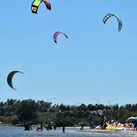 Kites dans le ciel au-dessus d'une plage de kitesurf