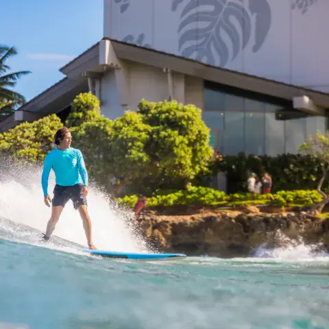Surfeur sur une vague au pied de l'hôtel