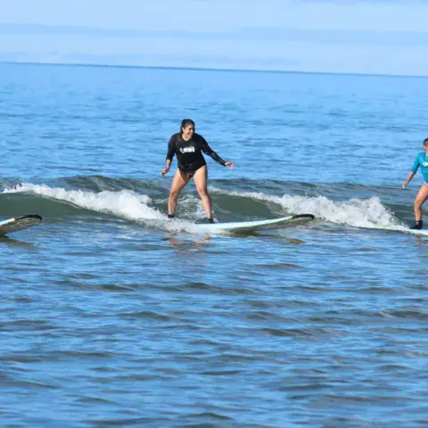Trois surfeurs debout sur leurs planches