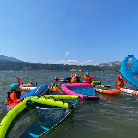 Groupe de pratiquants de wing foil et de paddle sur l'eau