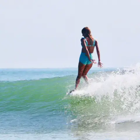 Surfeuse sur une longue vague