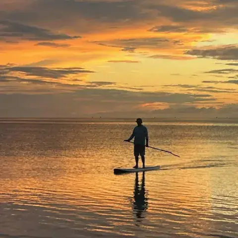Pagayeur sur un paddle au coucher du soleil