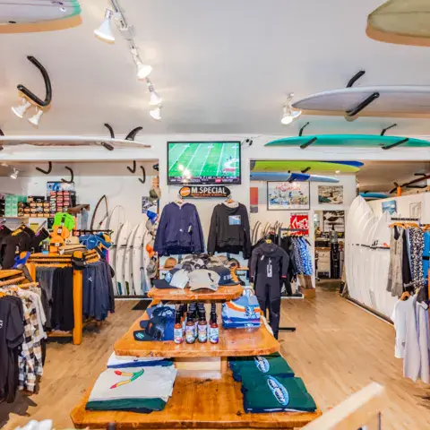 Rayon de vêtements et de planches de surf dans le magasin