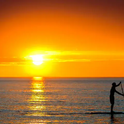 Pagayeur sur un paddle au coucher du soleil