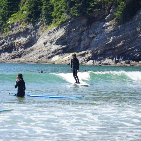 Élèves dans l'eau pendant un cours de surf