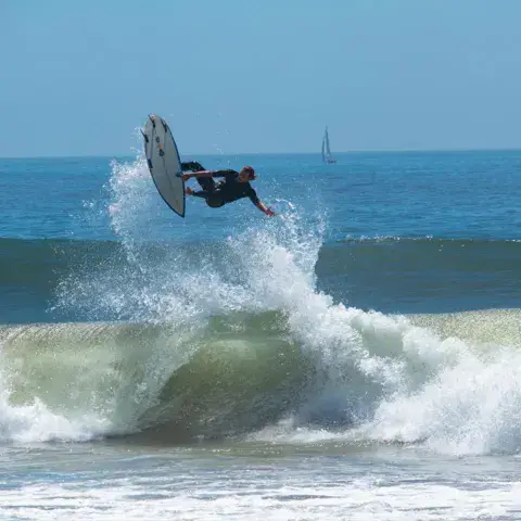 Surfeur en l'air au-dessus d'une vague