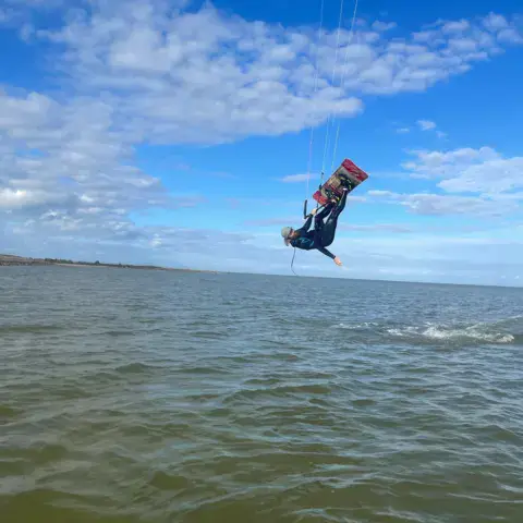 Saut en kitesurf au-dessus de l'eau