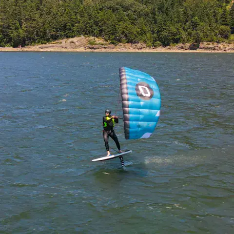 Rider en wing foil vu de loin, aile bleue