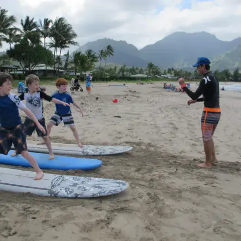 Explications à terre avant le cours de surf, sur la plage