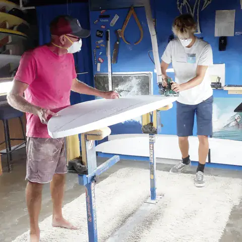 Deux personnes travaillent sur une planche en mousse