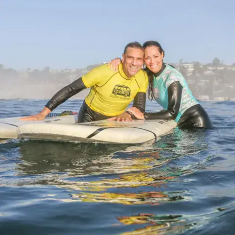 Deux élèves adultes allongés sur leurs planches dans l'eau