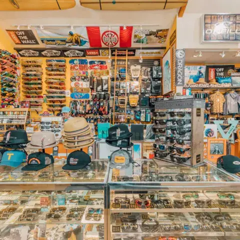 Vitrine du magasin avec casquettes, lunettes et skateboards