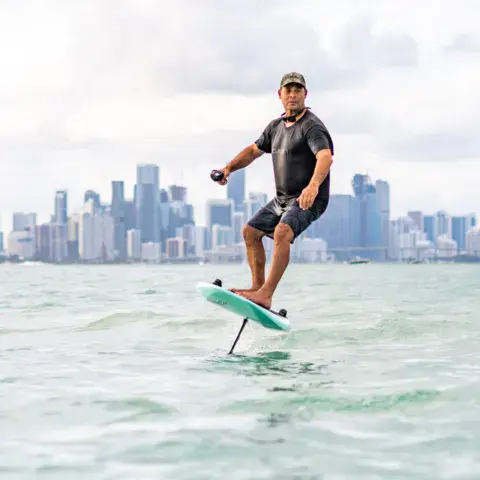 Rider sur un e-foil devant la skyline de Miami