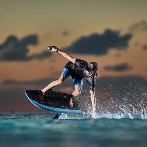 Rider sur un e-foil au coucher du soleil