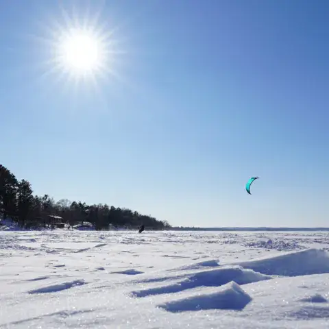 Séance de snowkite sur un lac enneigé