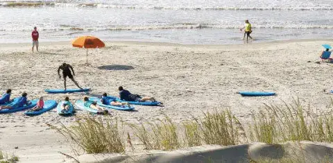 Camp installé sur la plage, avec une tente et des planches alignées sur le sable