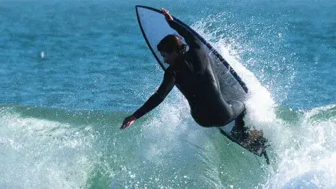 Surfeur en pleine manœuvre sur une vague