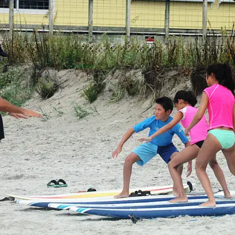Initiation sur le sable, planches alignées, avec un moniteur