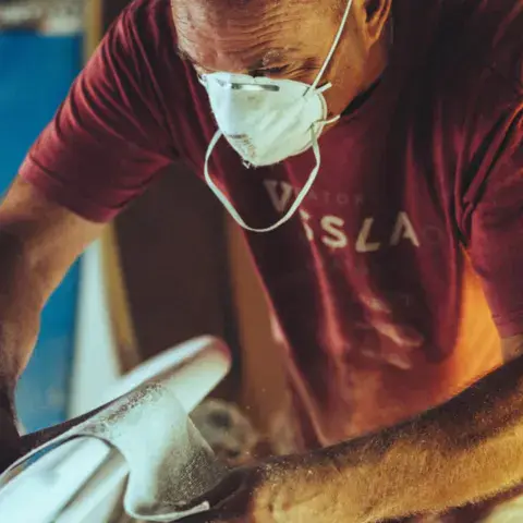 Ponçage d'une planche de surf à la main