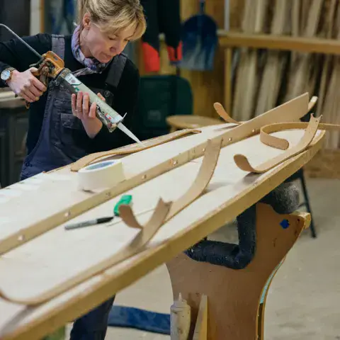 Collage de l'ossature d'une planche en bois à l'atelier