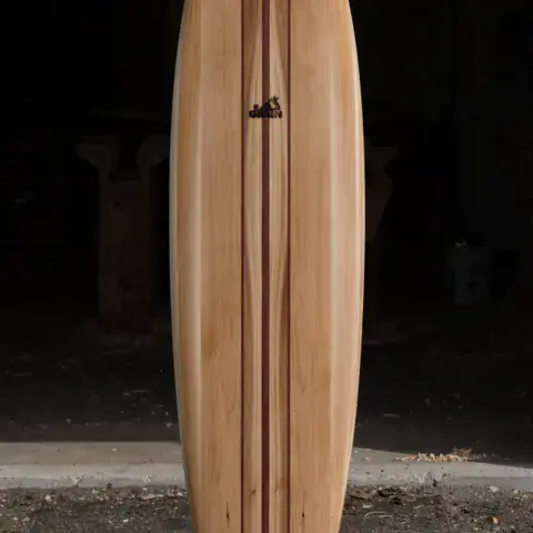 Planche de surf en bois finie, posée debout