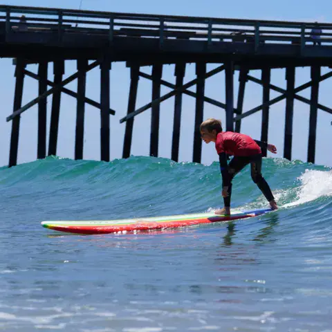 Surfeur sur une vague sous la jetée