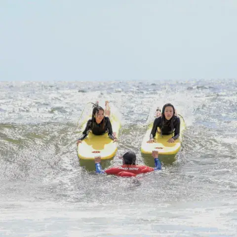 Deux élèves sur des planches en mousse dans l'écume