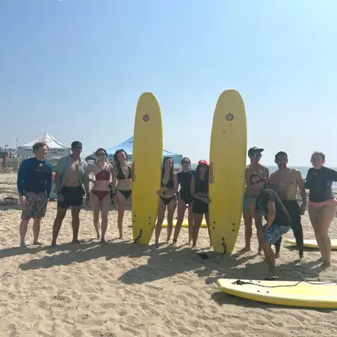 Groupe sur la plage avec deux planches jaunes