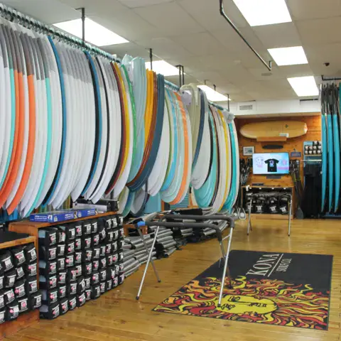 Rayon de planches de surf alignées dans le magasin