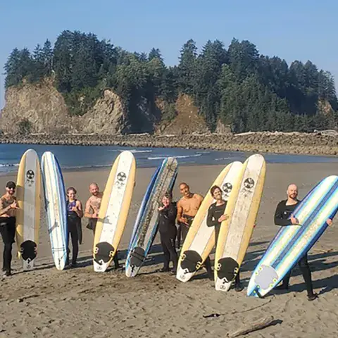 Groupe de surfeurs avec leurs planches sur la plage