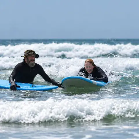 Deux surfeurs dans les vagues sur des planches souples