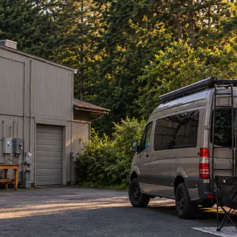 Van garé derrière le magasin, à l'emplacement de camping