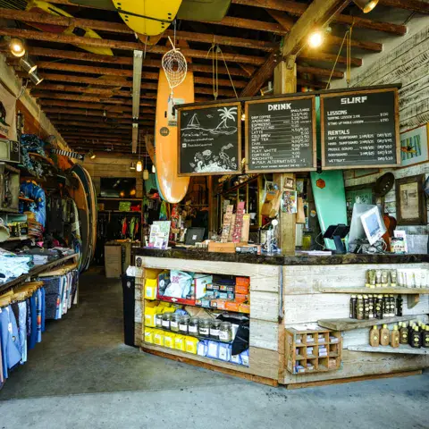 L'intérieur du magasin, avec le comptoir et les planches accrochées au plafond