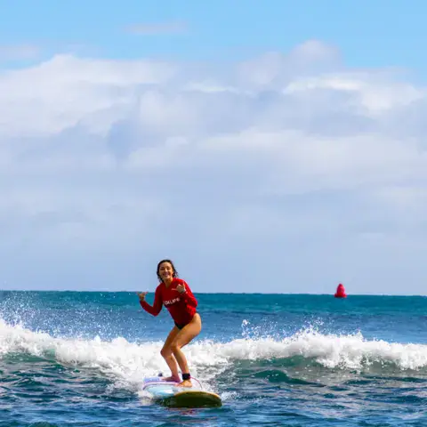 Surfeuse sur une vague au large de Kalapaki