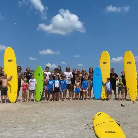 Groupe de stage sur la plage, avec les planches en mousse