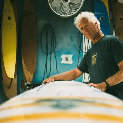 Shaper devant une planche dans l'atelier