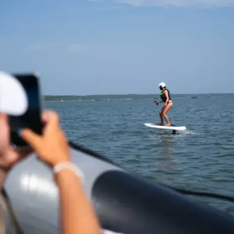 Séance de foil suivie depuis un bateau d'assistance