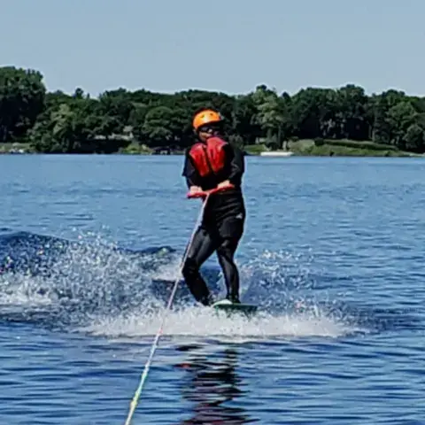 Élève tracté sur l'eau lors d'un cours de maîtrise de la planche