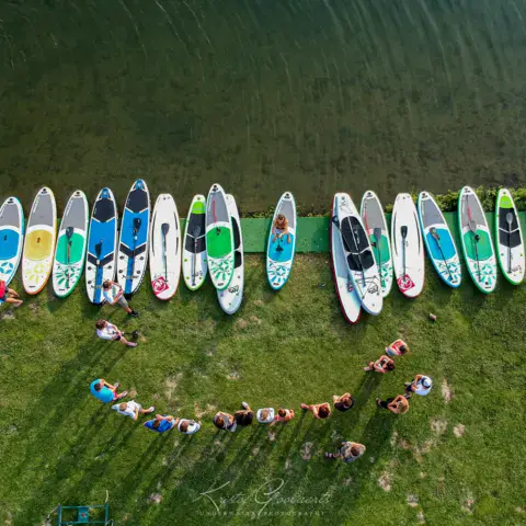 Planches de stand up paddle alignées sur la pelouse du club