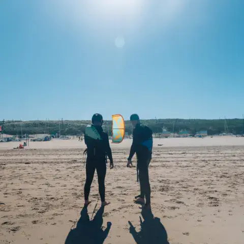 Deux kitesurfeurs sur la plage avant la session